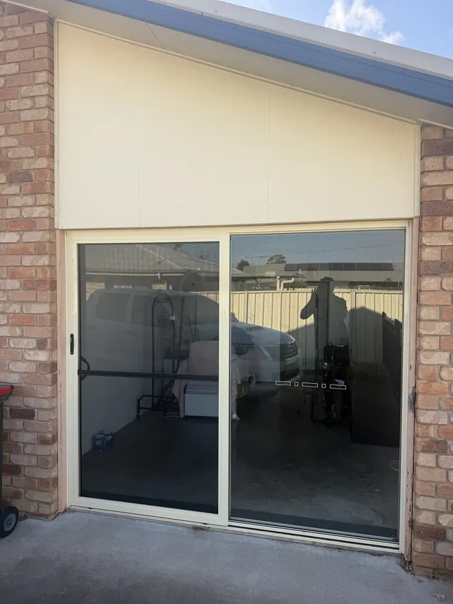 Sliding door and cladding fitted into a brick opening