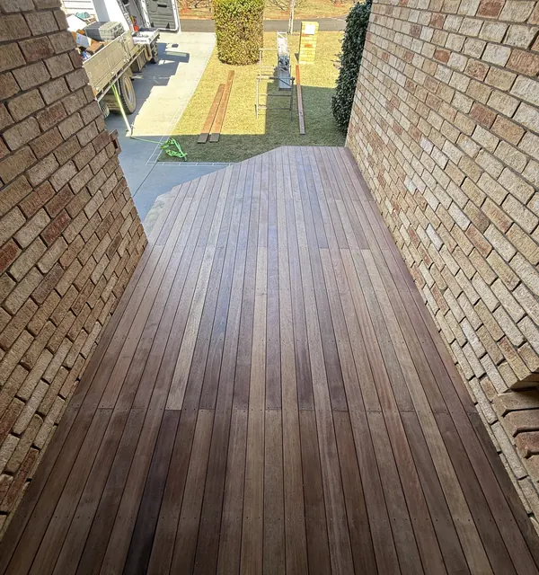 New hardwood deck running down the side of a brick home